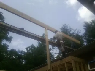 Carpenter setting a ridge beam over a new addition frame — Ice Dam Removal by Roofing Brothers in Yerington