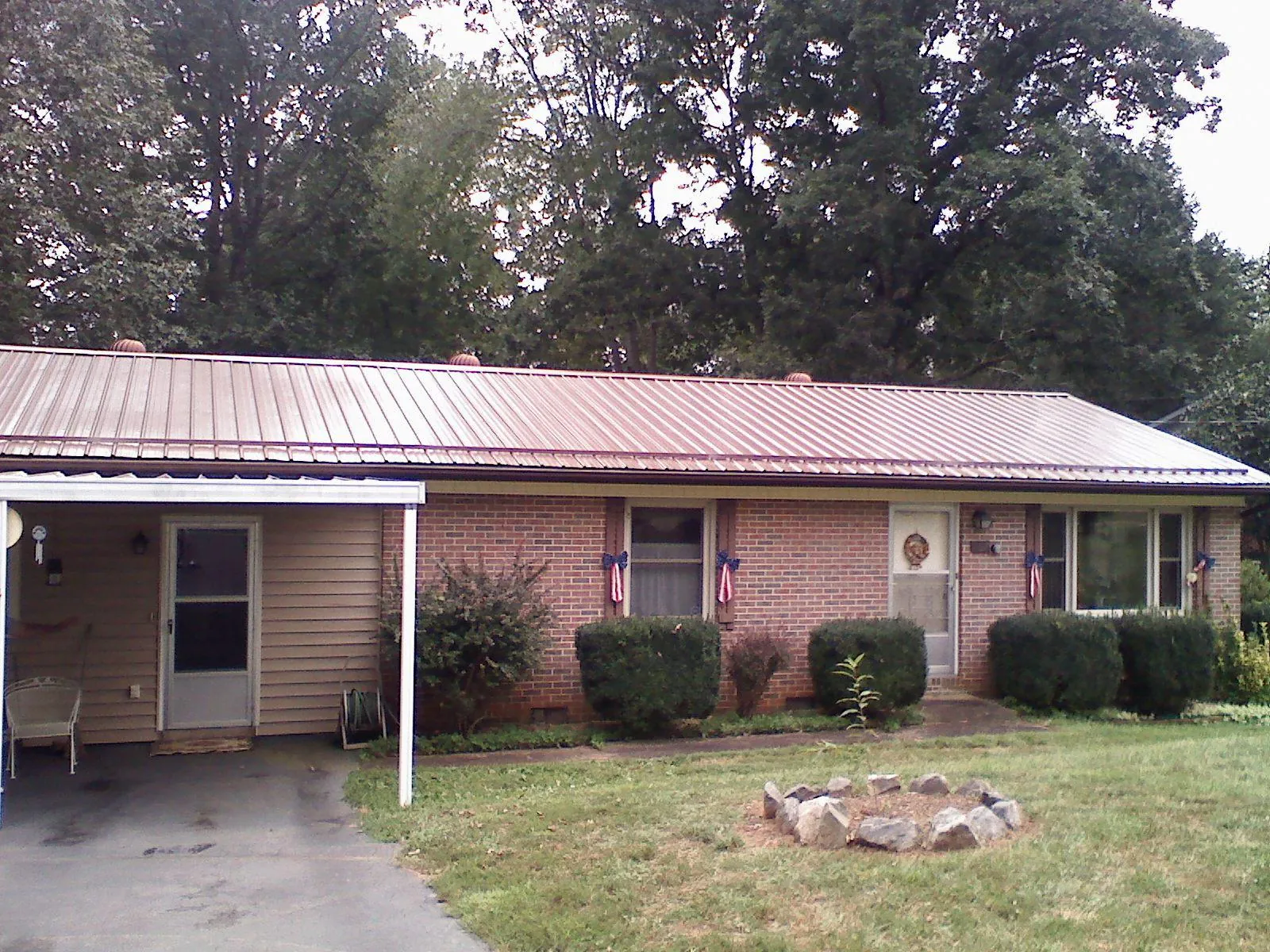 Bronze metal roof and carport on a brick ranch home — Roof Repair work by our crew in Yerington